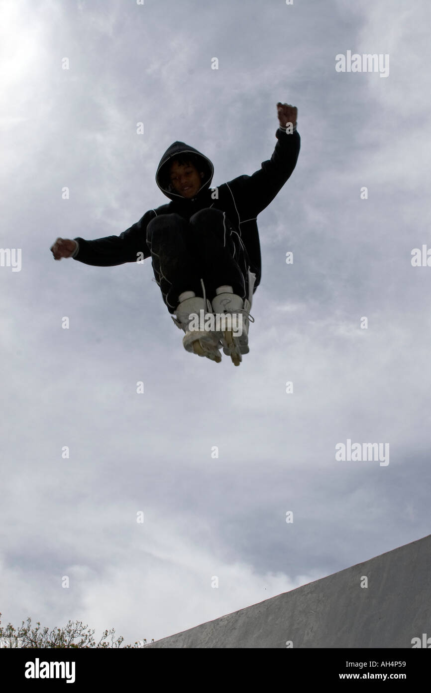 Young man or boy doing trick stunt jumps on rollerblades flying in mid