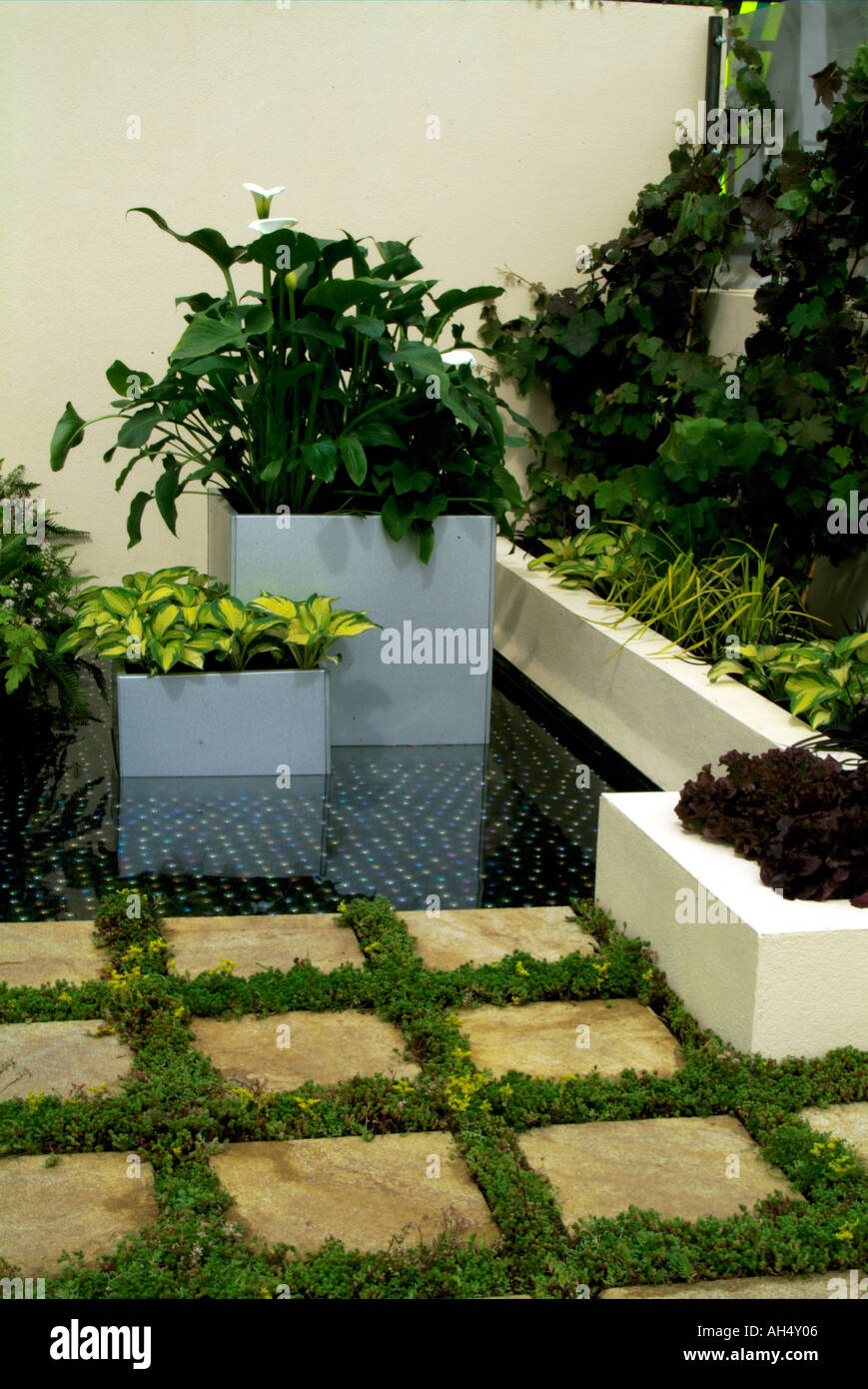 Garden pool, square planters with hosta and raised beds with paving