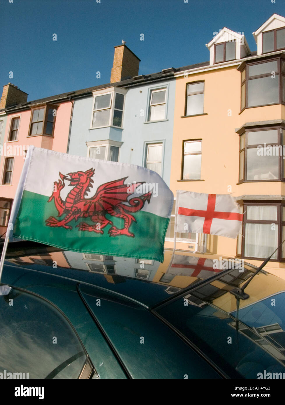 Y Ddraig Goch welsh red dragon banner and cross of St George on car Aberystwyth promenade summer evening Stock Photo