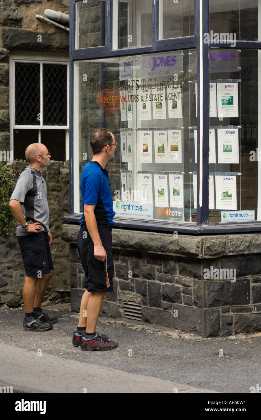Two men Looking at house prices in an estate agent's window, Dolgellau snowdonia gwynedd north wales UK Stock Photo