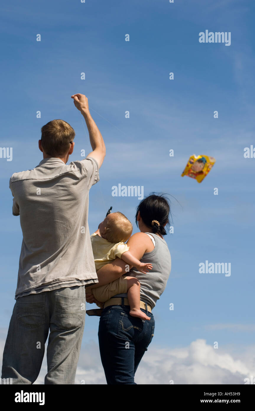 Holidaymaker family mother father flying kite  in the sunshine on Constitution Hill 'Consti' Aberystwyth  Ceredigion Wales Cym Stock Photo