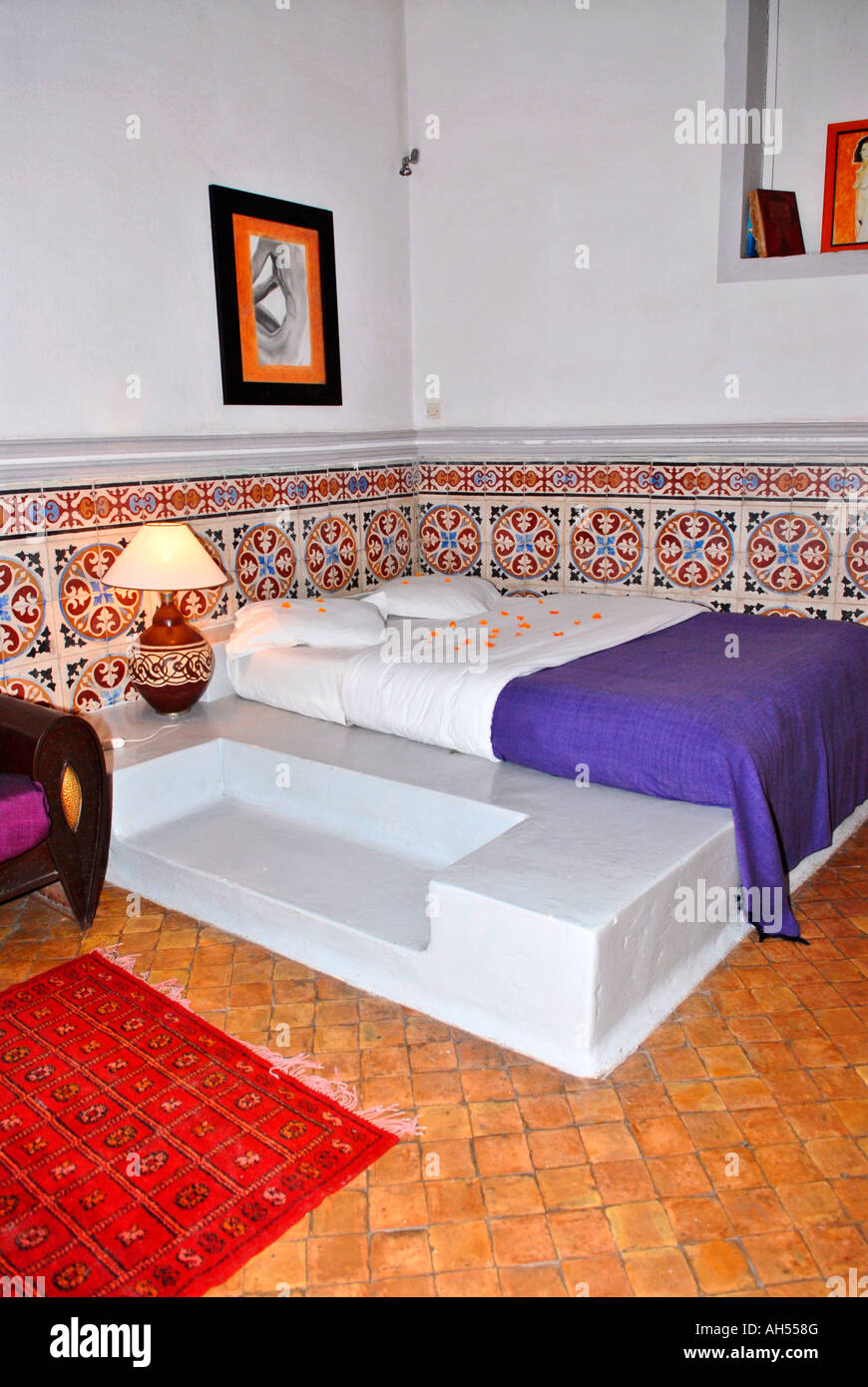 Morocco , Essaouira , Riad El Madina , typical African hippy hotel scene of beige suite with rugs & traditional tiled walls Stock Photo