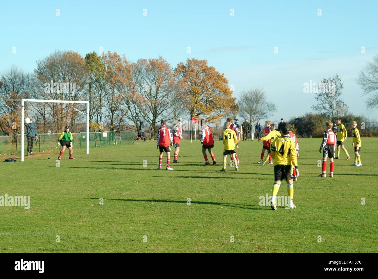 Teenage boys wearing team kit playing organised refereed football match game watched by spectators & parents Mountnessing Brentwood Essex England UK Stock Photo