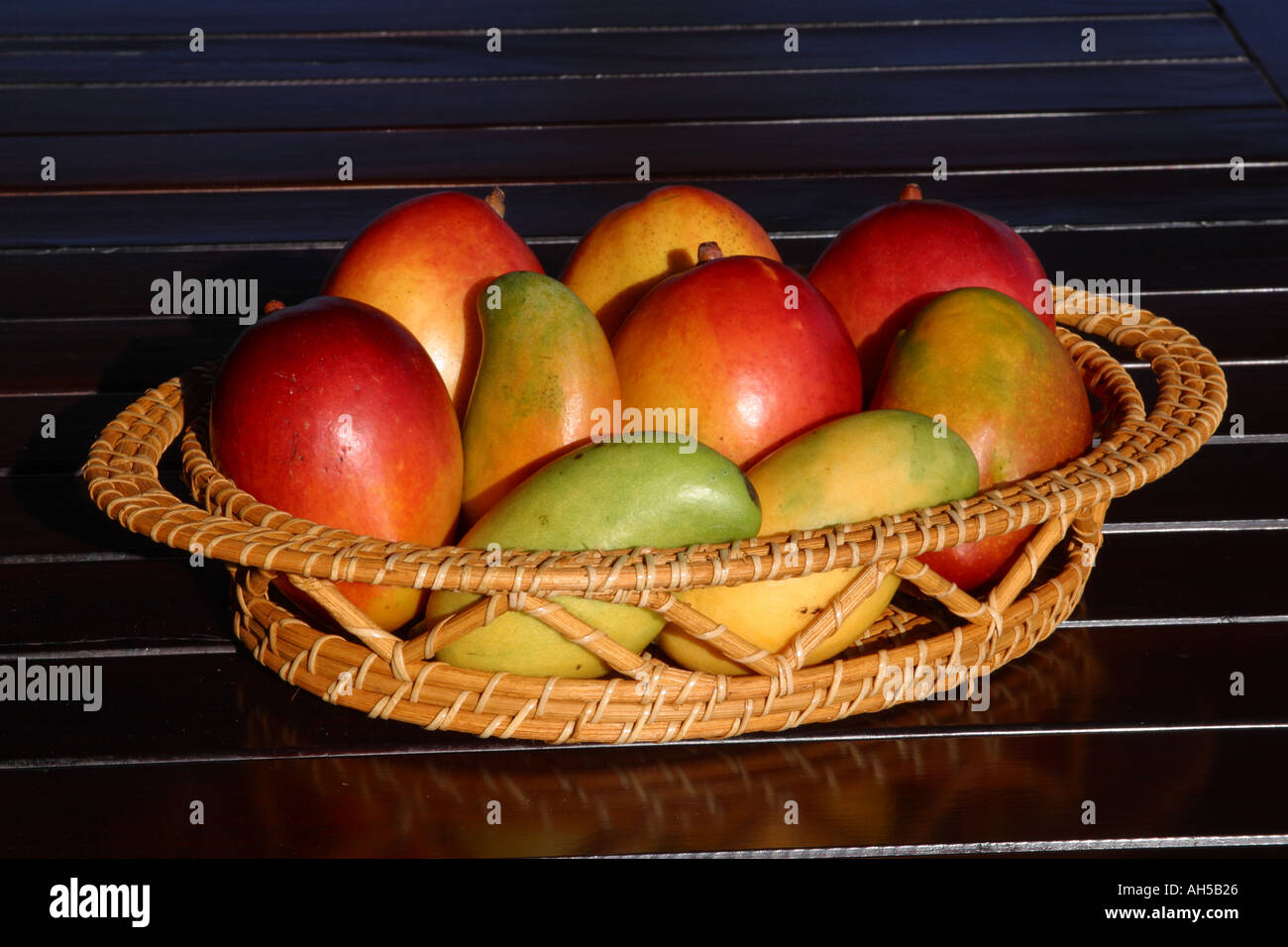 Mangoes in fruit basket with black background Stock Photo