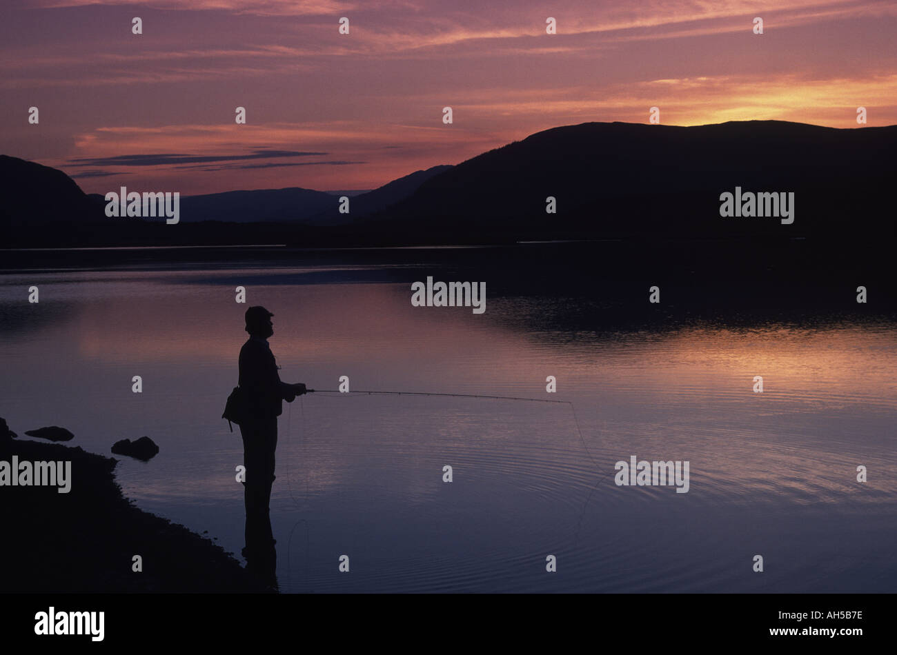 Fly fishing for trout on Spey Dam Inverness shire Scotland at sunset