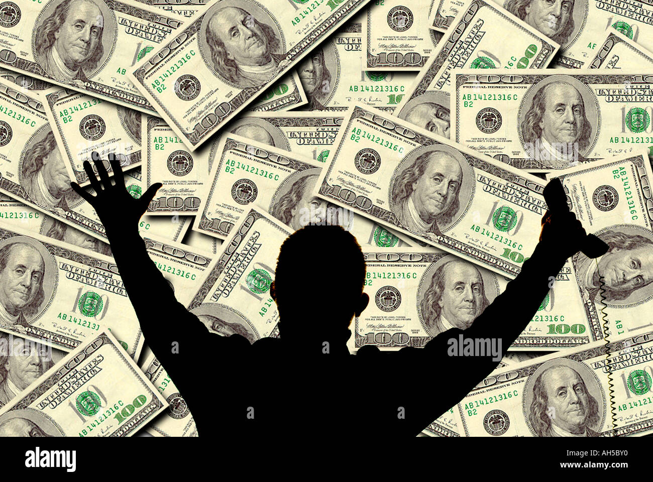 silhouette of businessman with telephone and arms outstretched with background of one hundred dollar bills Stock Photo