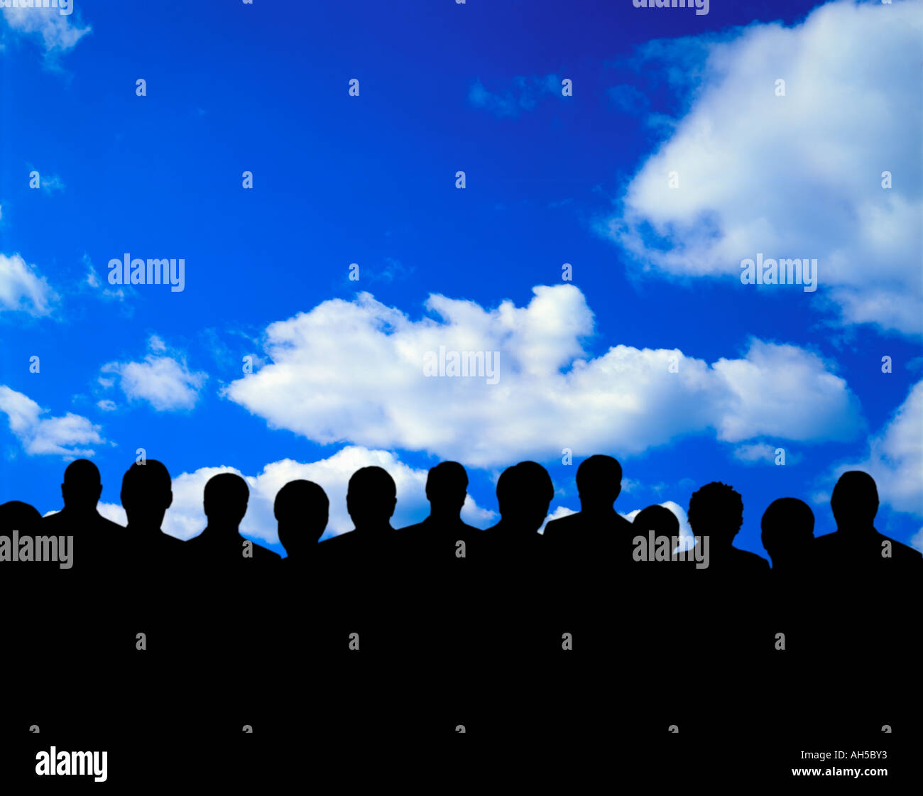 group of people silhouetted against sky and clouds Stock Photo