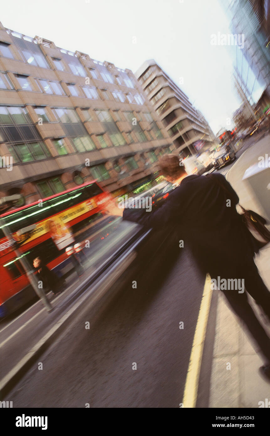 Man hailing taxi in London city street with blurred movement in background  Stock Photo