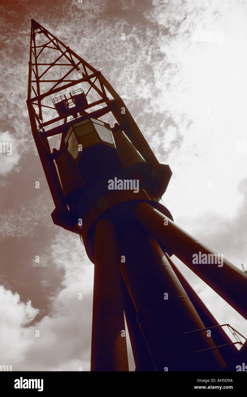 A Large dockyard crane towering against cloudy sky with sepia effect Stock Photo