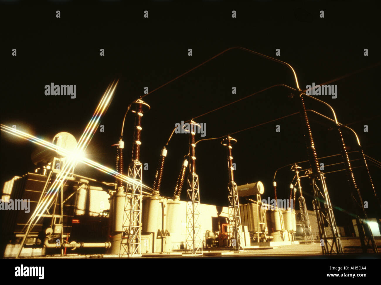 Large power transformer and switchyard at night with starburst effect at atomic accelerator station CERN Switzerland  Stock Photo