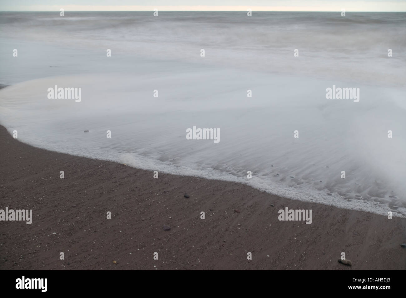 Shoreline surf at dawn on Ness Beach Shaldon Devon Great Britain Stock Photo