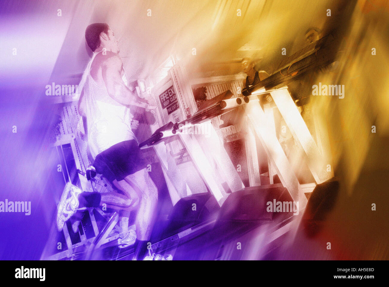 Male on running machine with violet and yellow lighting Stock Photo - Alamy