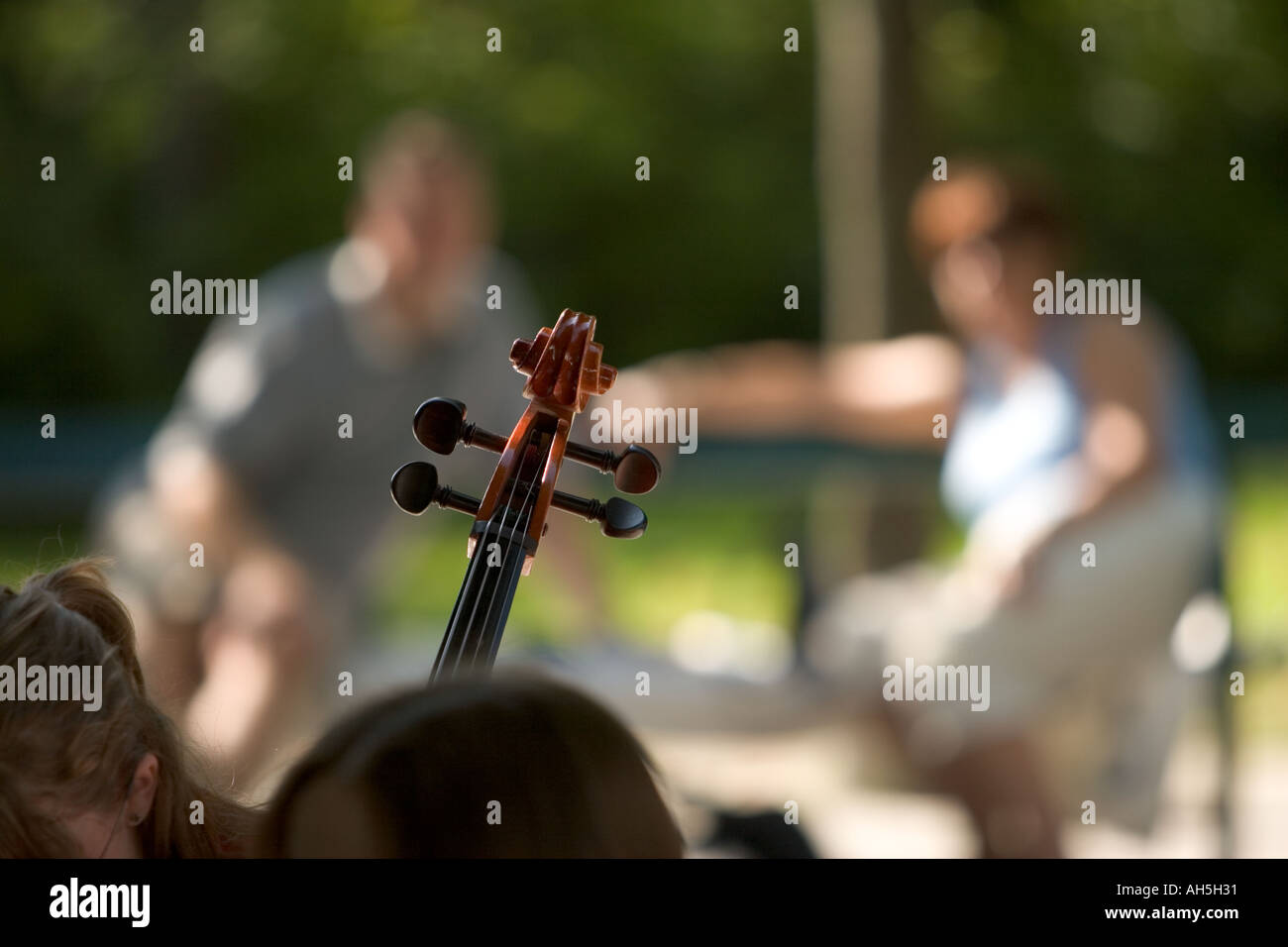 A couple sat looking at cello during outdoor concert in Mirabell Gardens Salzburg Austria Stock Photo