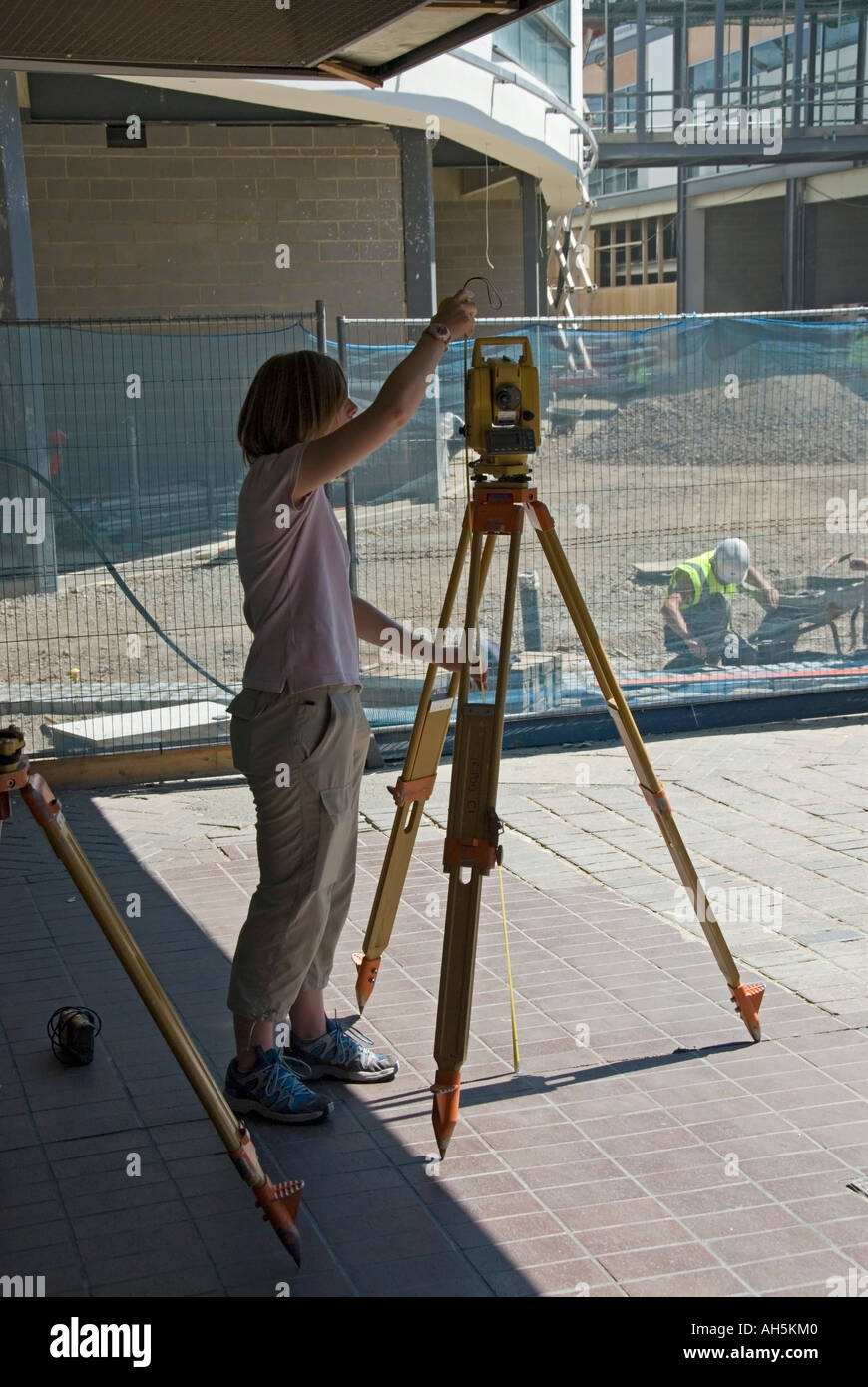 Female Land Surveyor Taking Down Measurements In A Shopping Centre - female land surveyor taking down measurements in a shopping centre