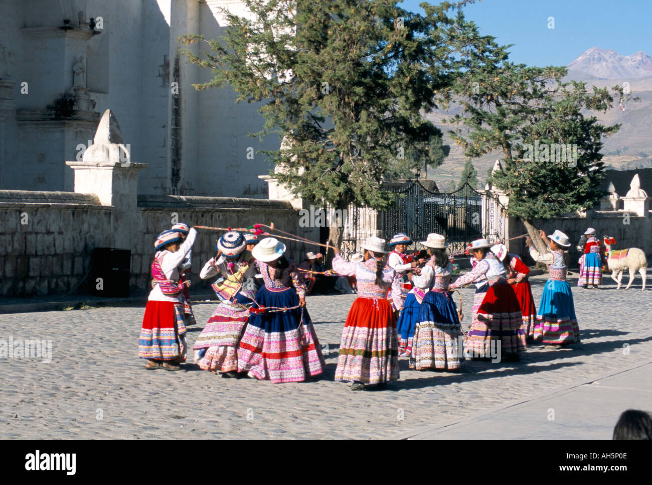 Girls in traditional local dress dancing in square at Yanque village Colca Canyon Peru South America Stock Photo