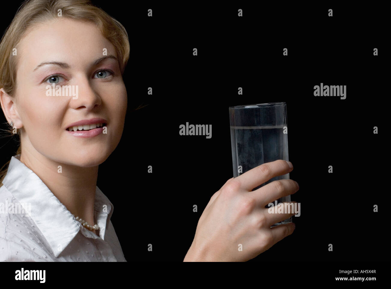 Portrait of a young woman holding a glass of water Stock Photo