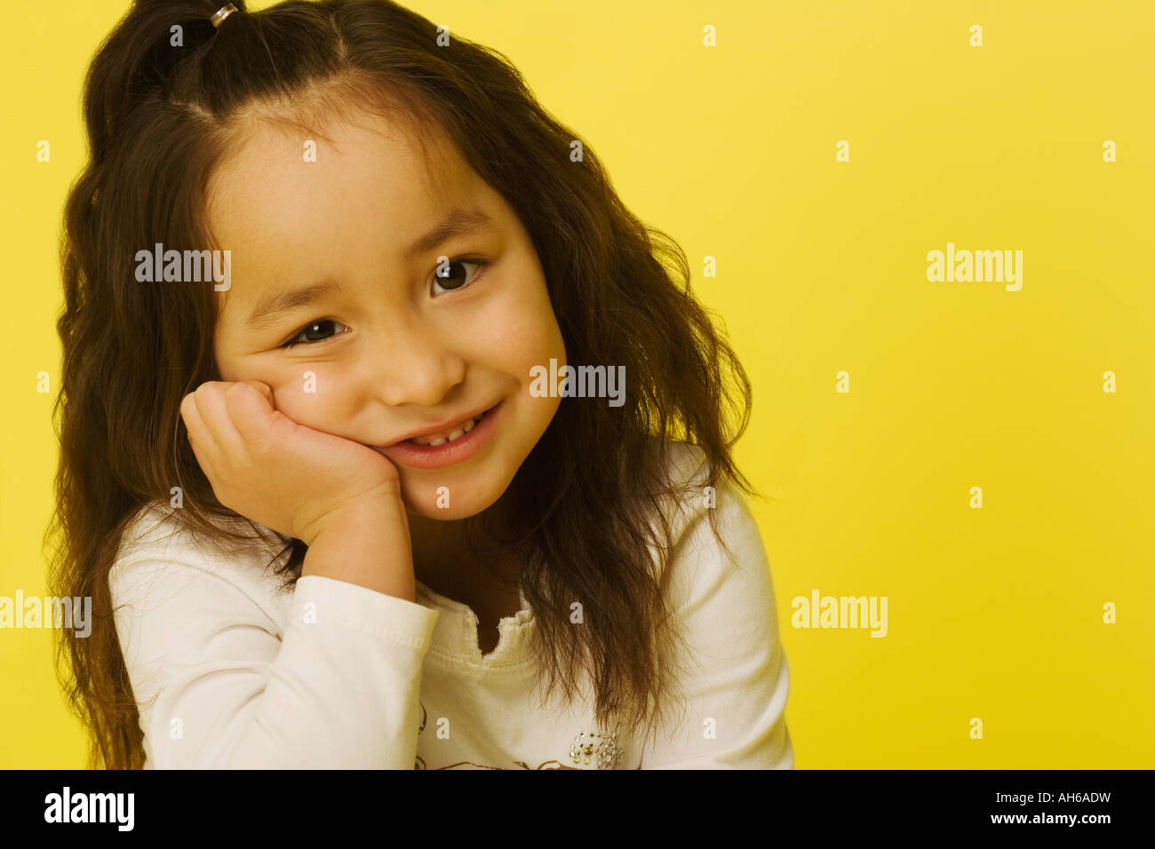 Portrait of a little girl with a yellow background Stock Photo - Alamy