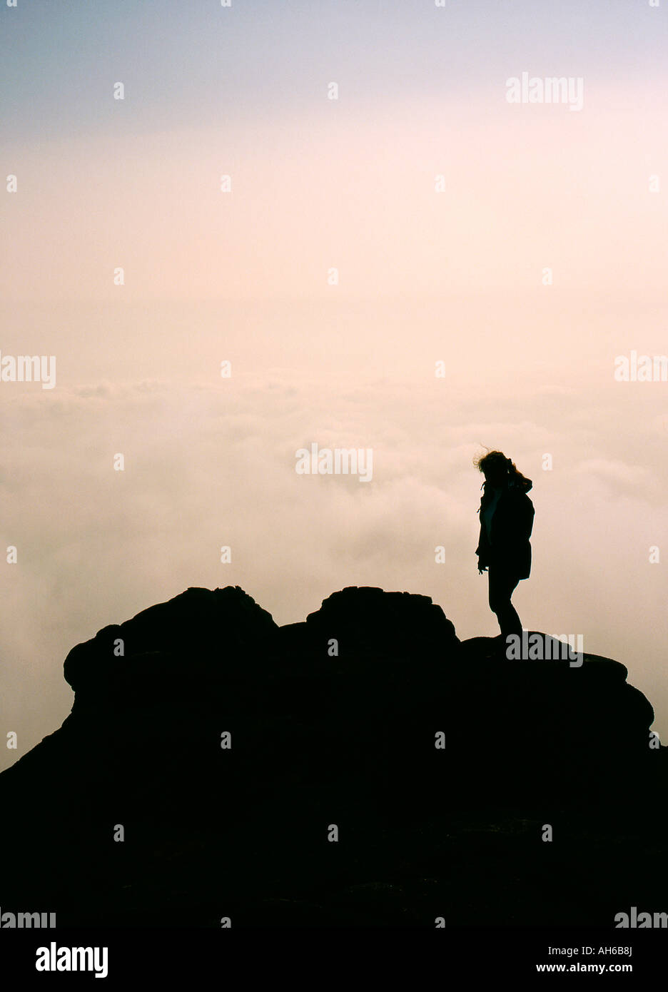 Silhouette of figure on mountain top above the clouds Stock Photo - Alamy