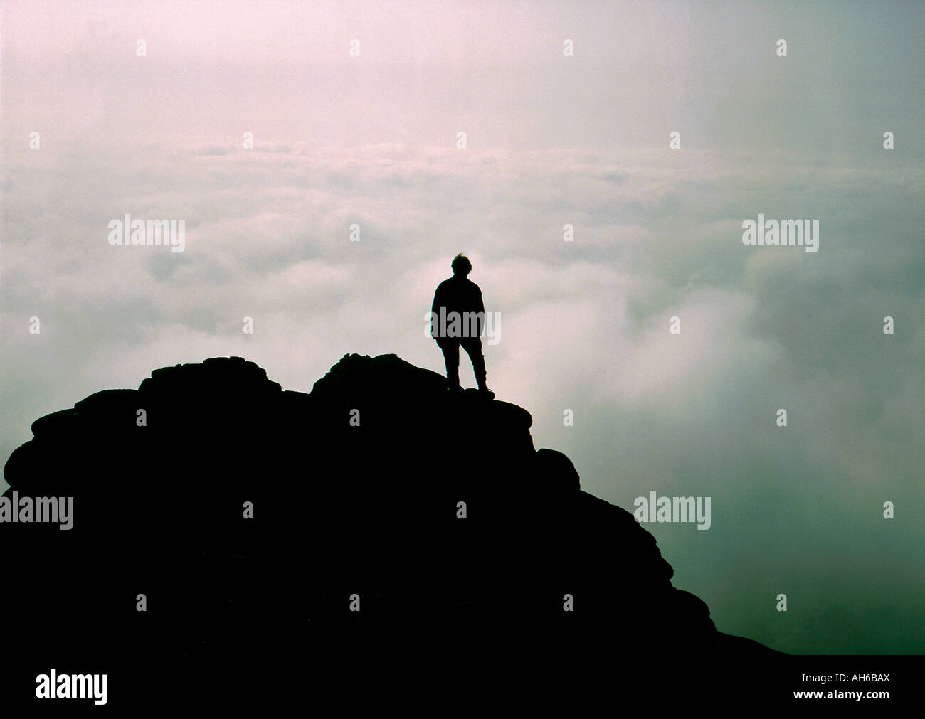 Silhouette of figure on mountain top above the clouds Stock Photo - Alamy