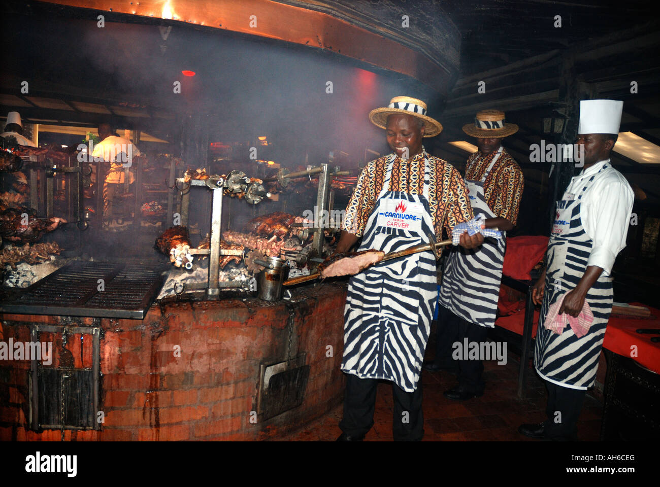 Three cooks working at the grill of the Carnivore Restaurant Nairobi Kenya East Africa Stock Photo