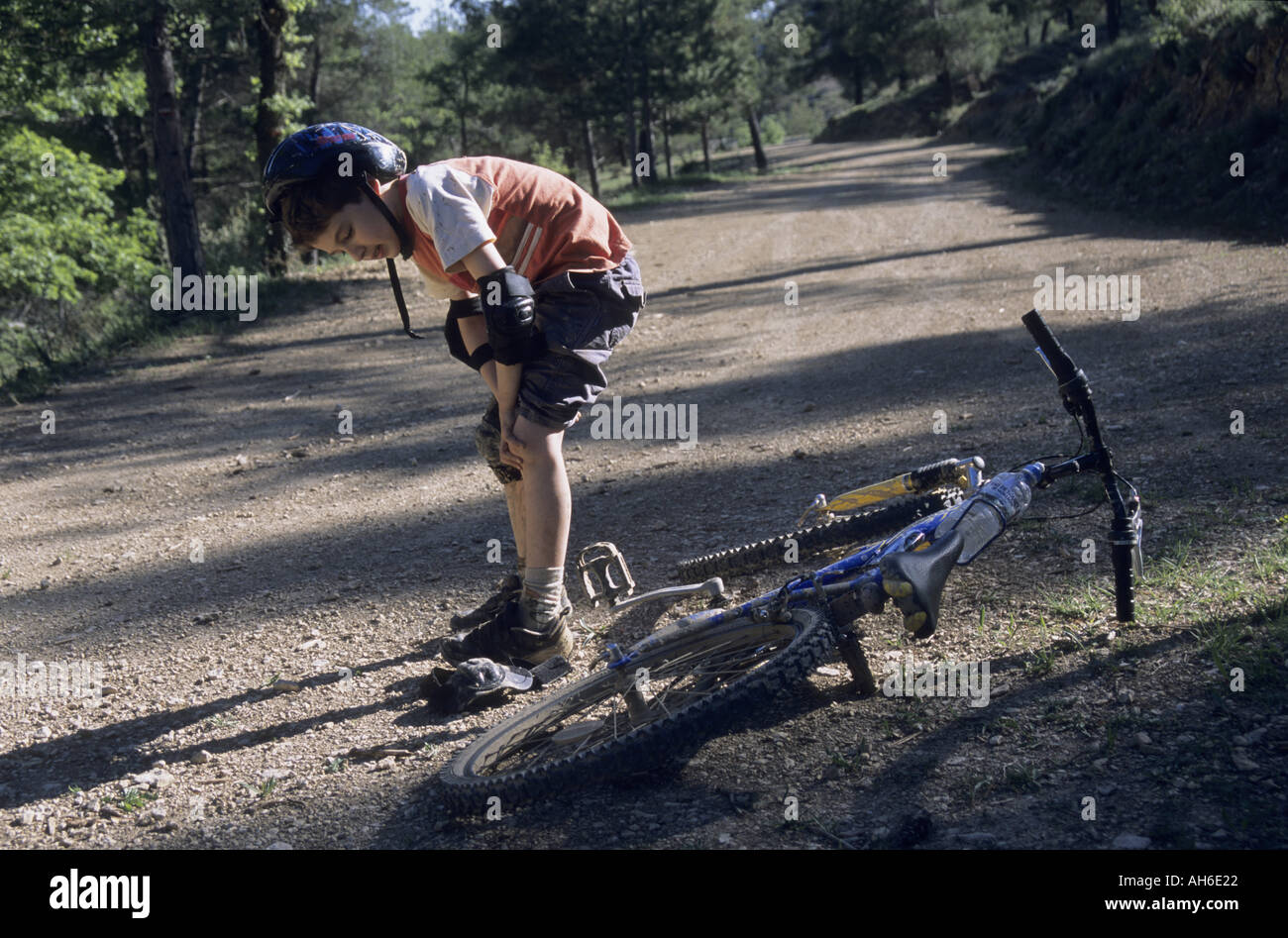 Boy rubbing his knee after falling off his bike, VitrollesenLuberon, Provence, France Stock