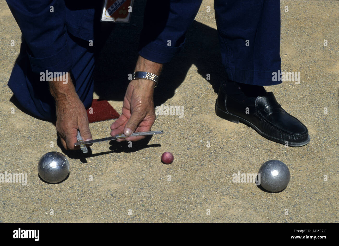 Player Of The French Boules Game Measuring Distance Between Two Boule, Provence, France Stock Photo