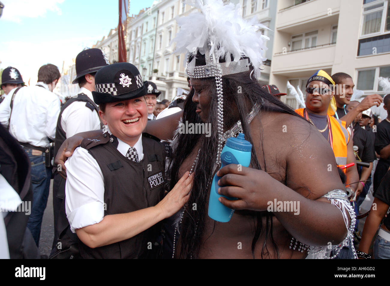 policewoman interacting and posing with very large black dancer at Notting Hill carnival. Stock Photo