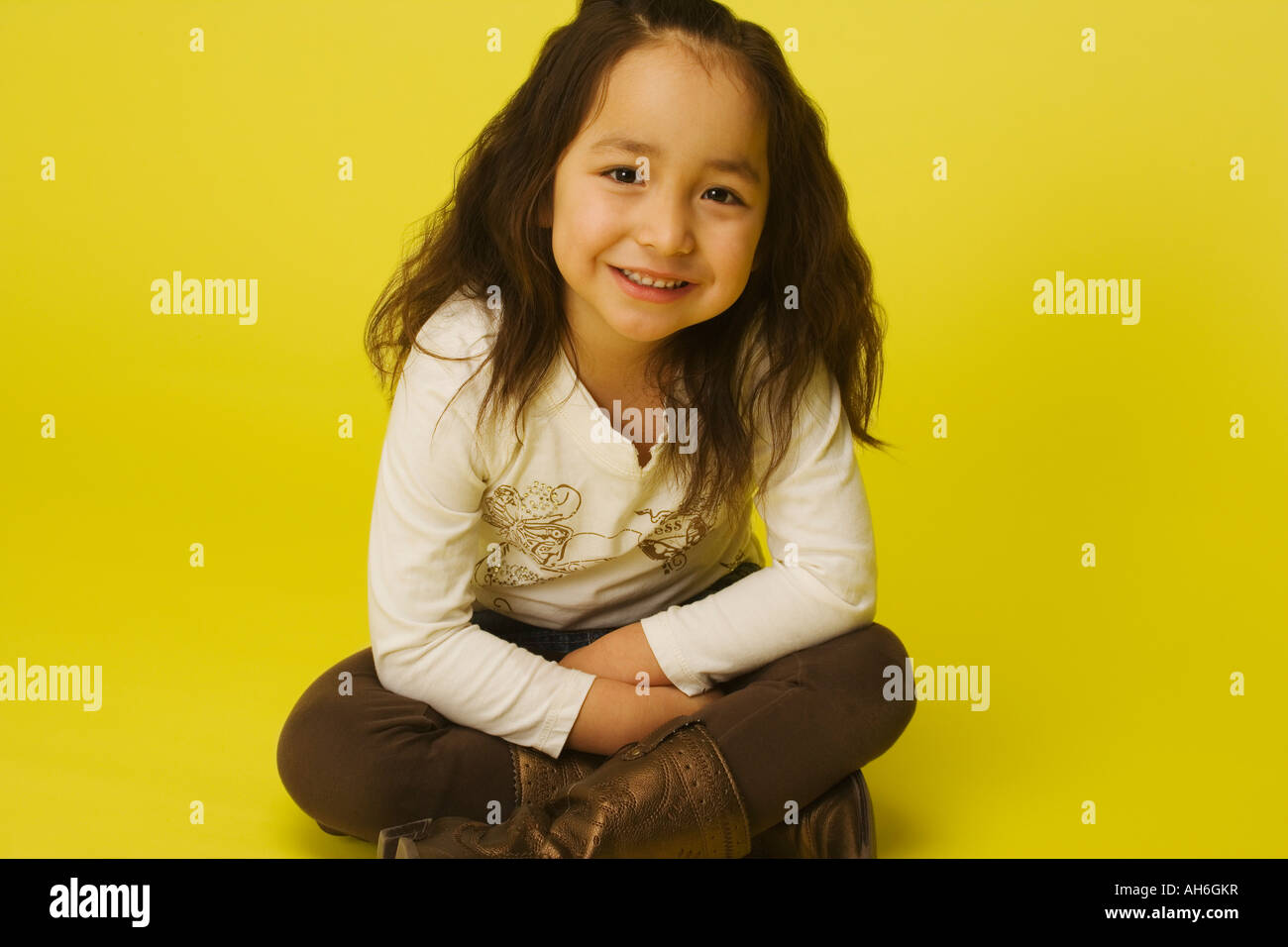 Little girl sitting cross legged Stock Photo - Alamy