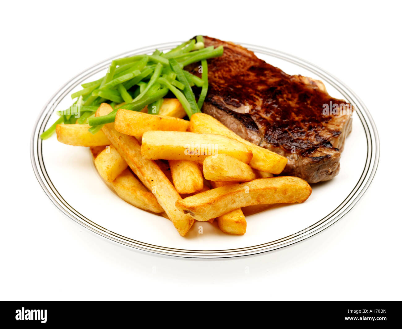 Freshly Cooked Lean Tender Sirloin Beef Steak With Chips and Green Runner Beans Against A White Background with A Clipping Path And No People Stock Photo