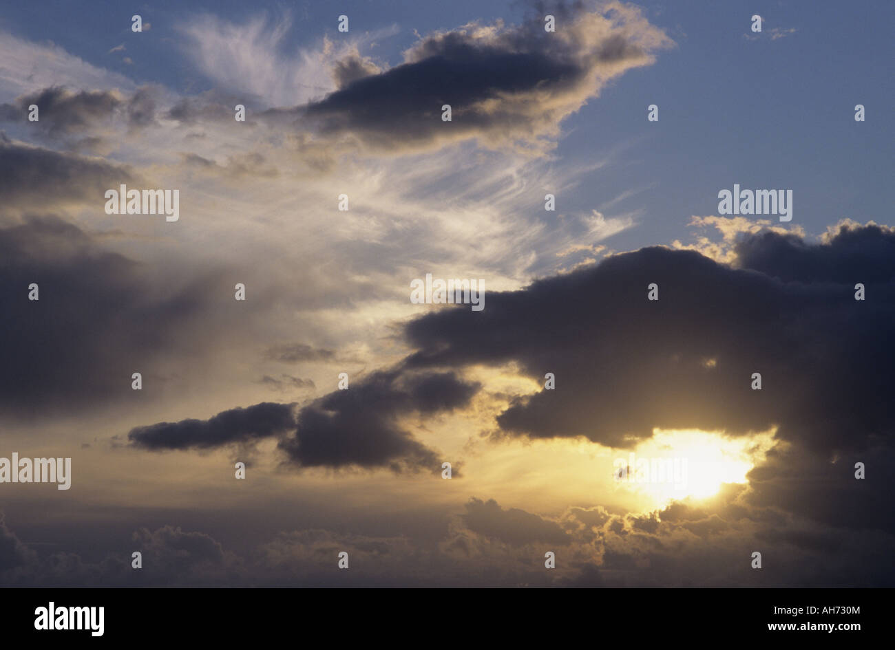 Evening sun behind clouds Stock Photo