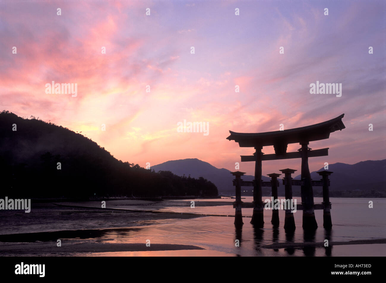 The famous floating torii shrine gate during a dramatic sunset in the Inland Sea just off the island of Miyajima Stock Photo