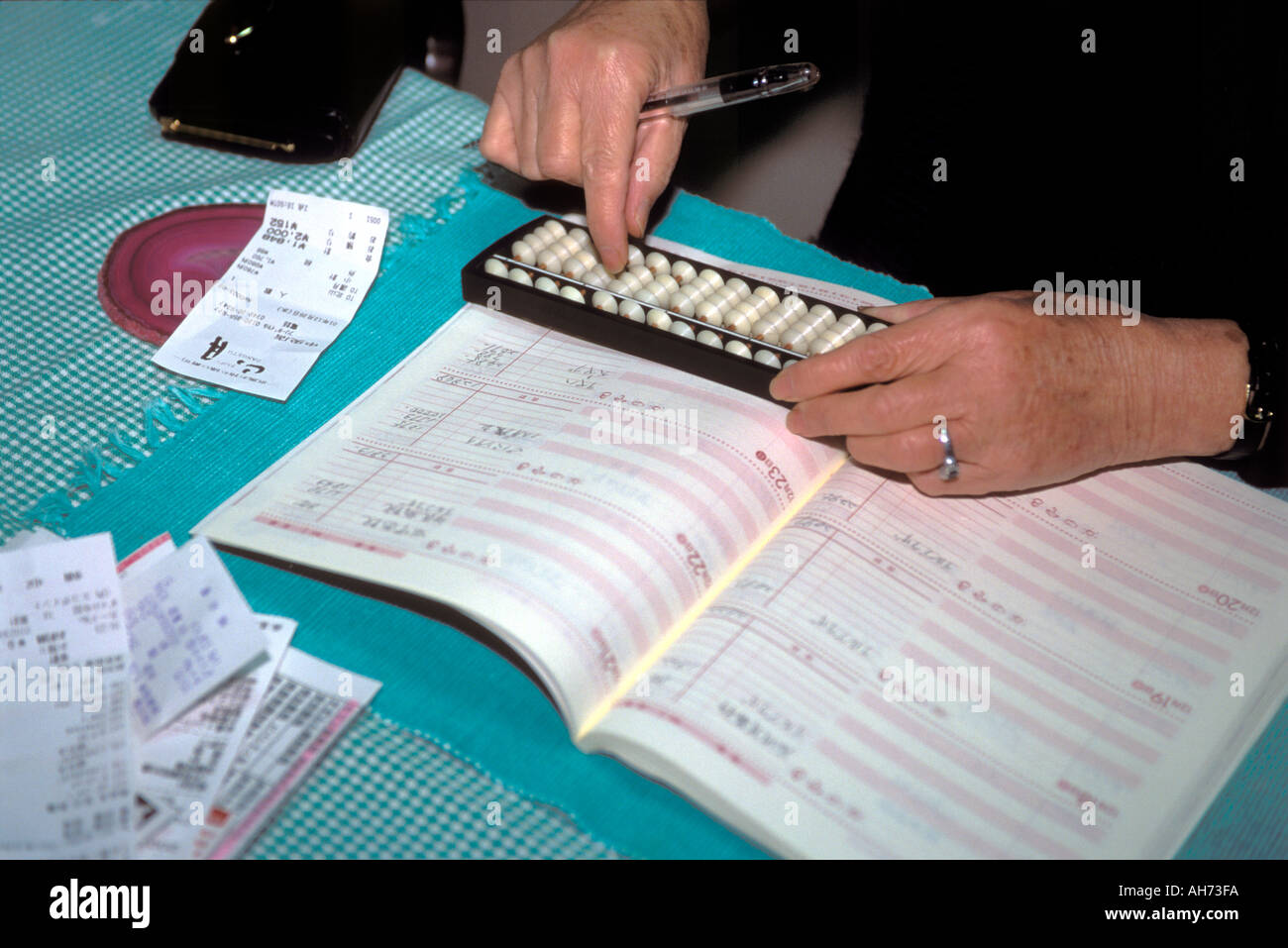 A person uses an old fashioned wooden Japanese soroban, or abacus, for calculating groups of numbers, Japan. Stock Photo