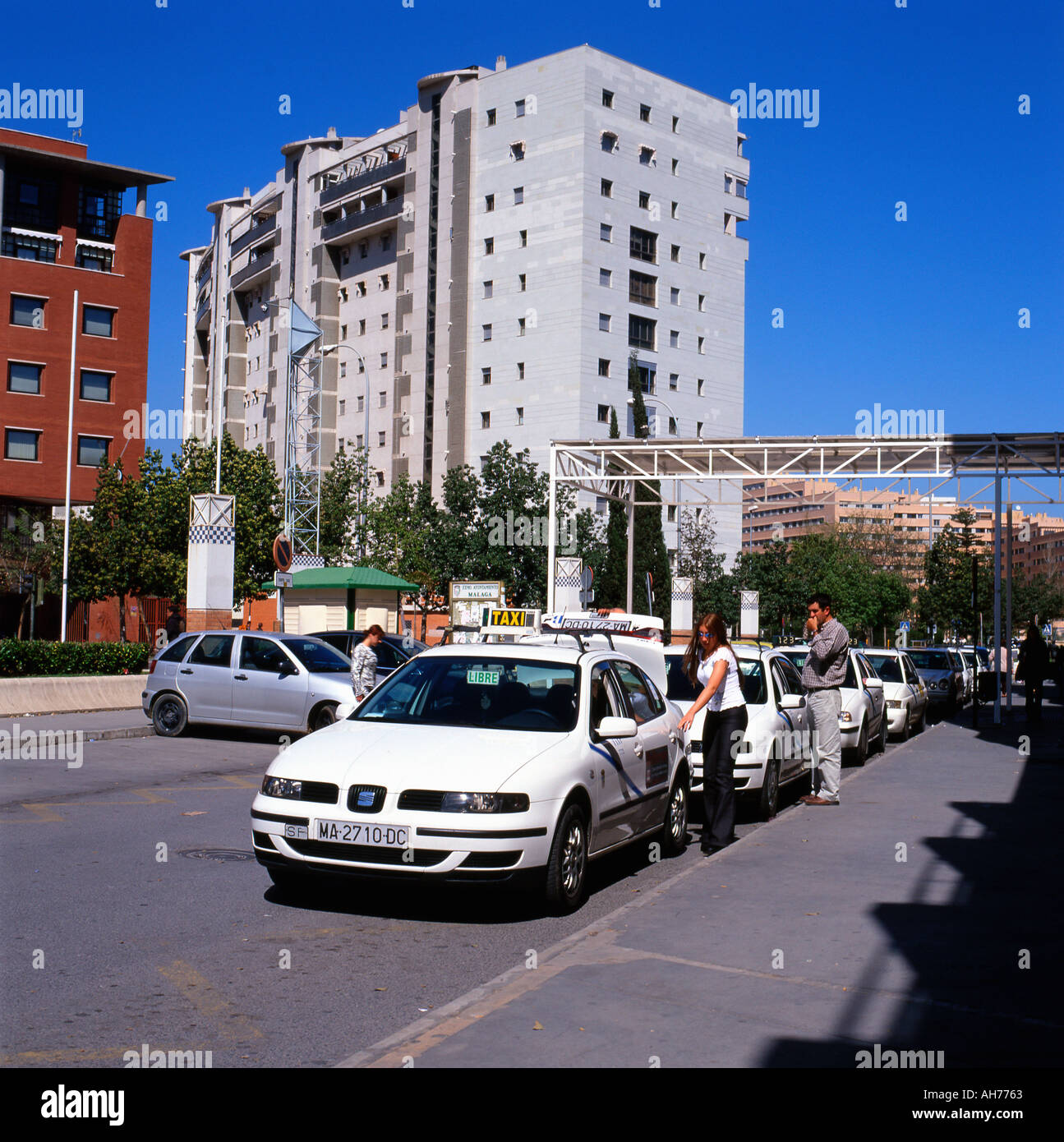 Person young woman opening the door and getting into a taxi cab at the bus station in Malaga Spain Europe EU   KATHY DEWITT Stock Photo