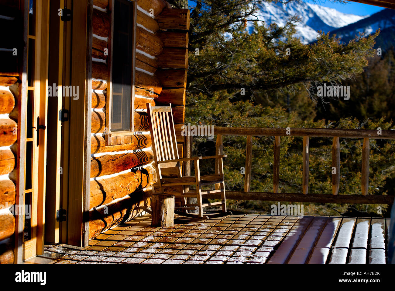 Rocking Chair On The Front Porch Of A Log Cabin Stock Photo
