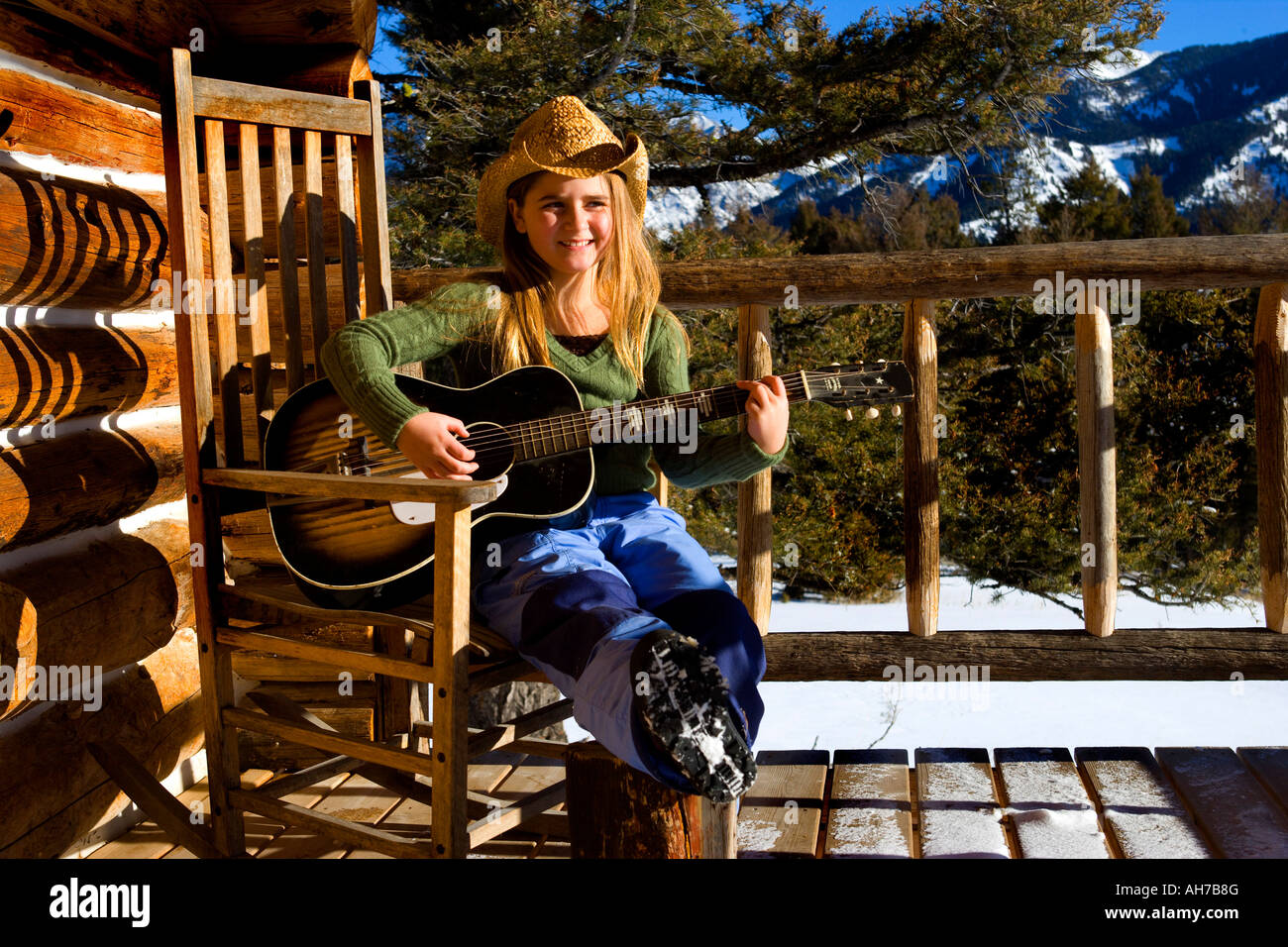 Girl sitting in a rocking chair and playing a guitar Stock Photo Alamy