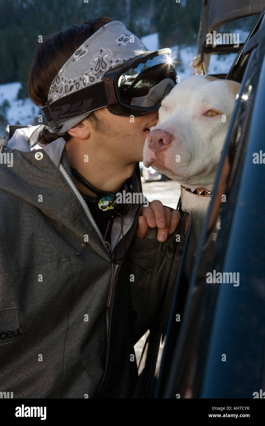 Young man biting a dog Stock Photo