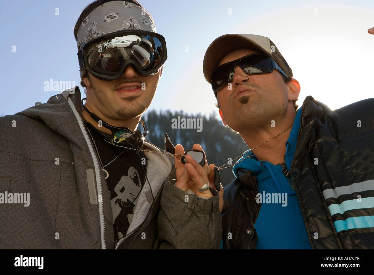 Closeup of a mid adult man and a young man showing their dog tags