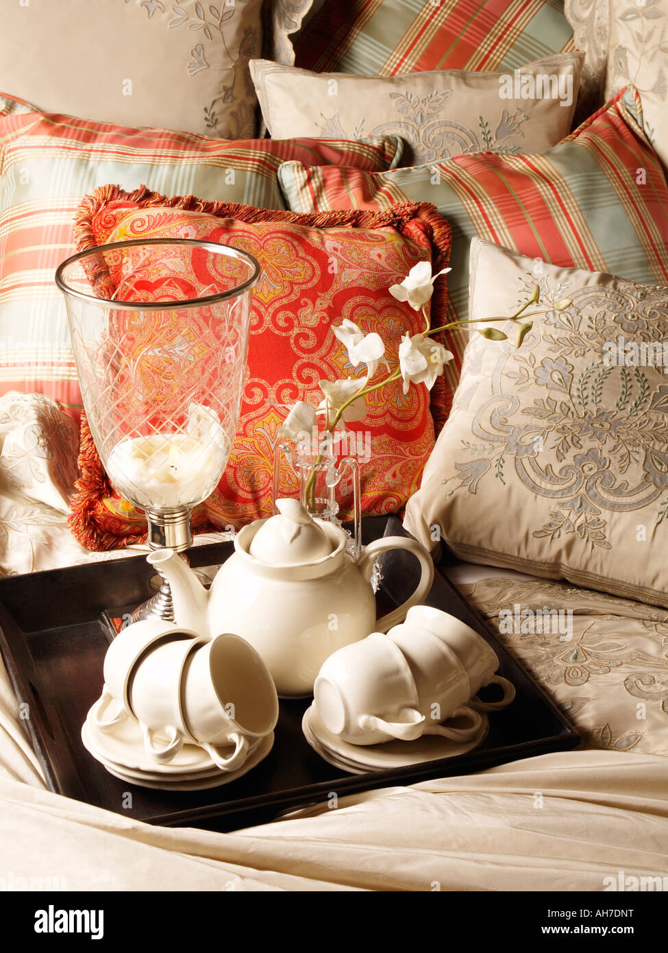 Tray with white porcelain classic tea set on bed decorated with many pillows interior design Stock Photo