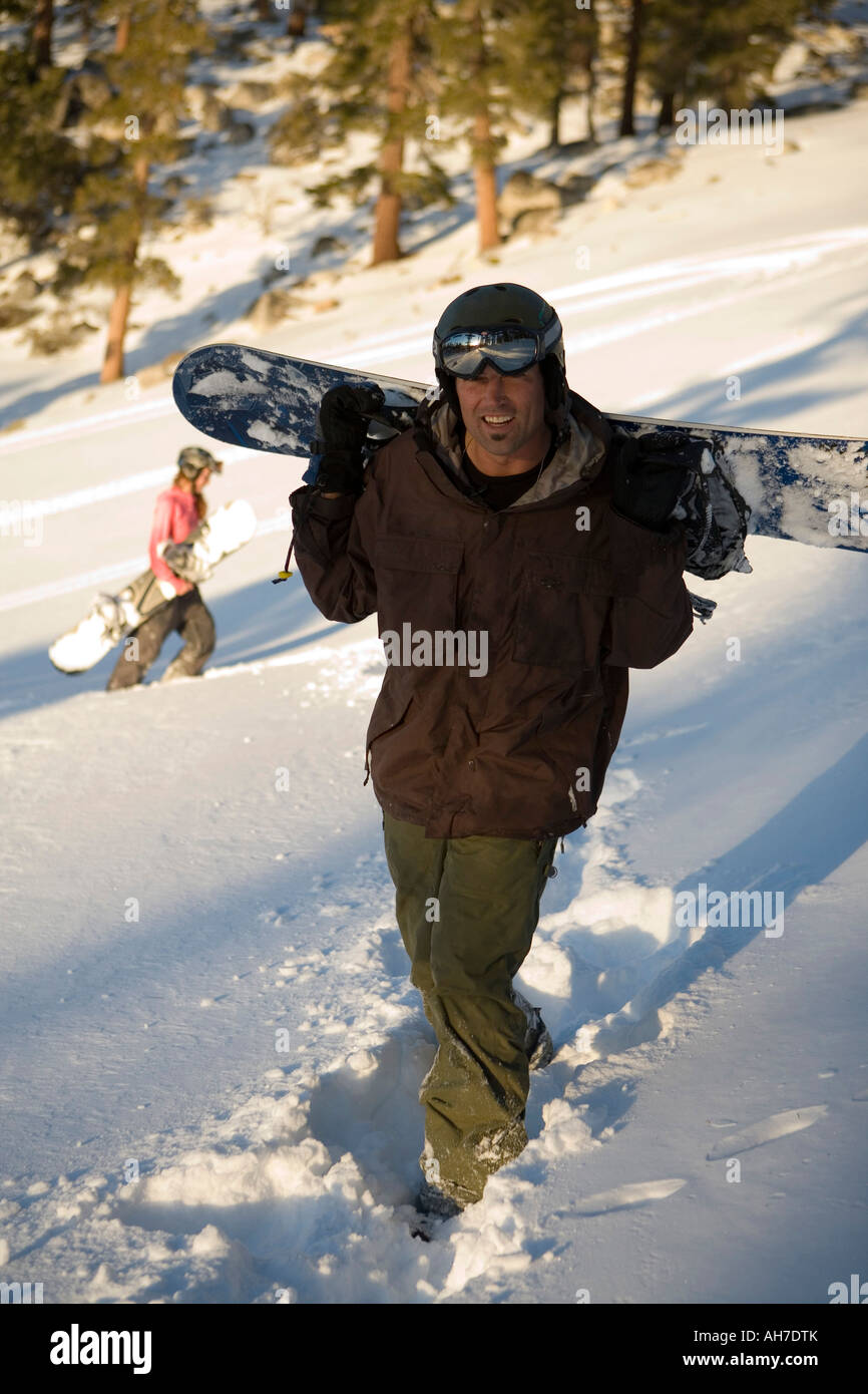 Mid adult man carrying a snowboard Stock Photo - Alamy