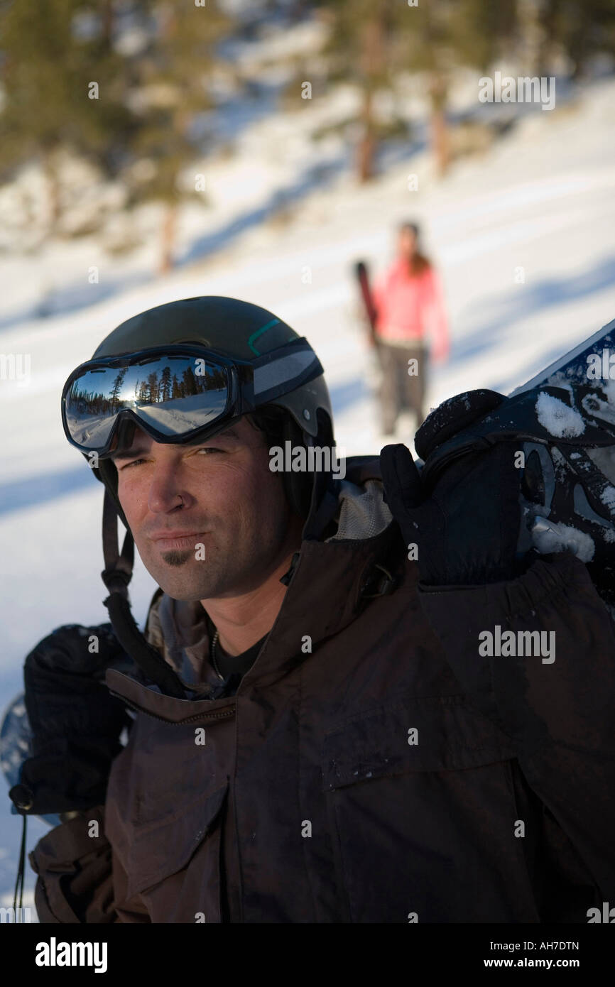 Portrait of a mid adult man carrying a snowboard Stock Photo - Alamy