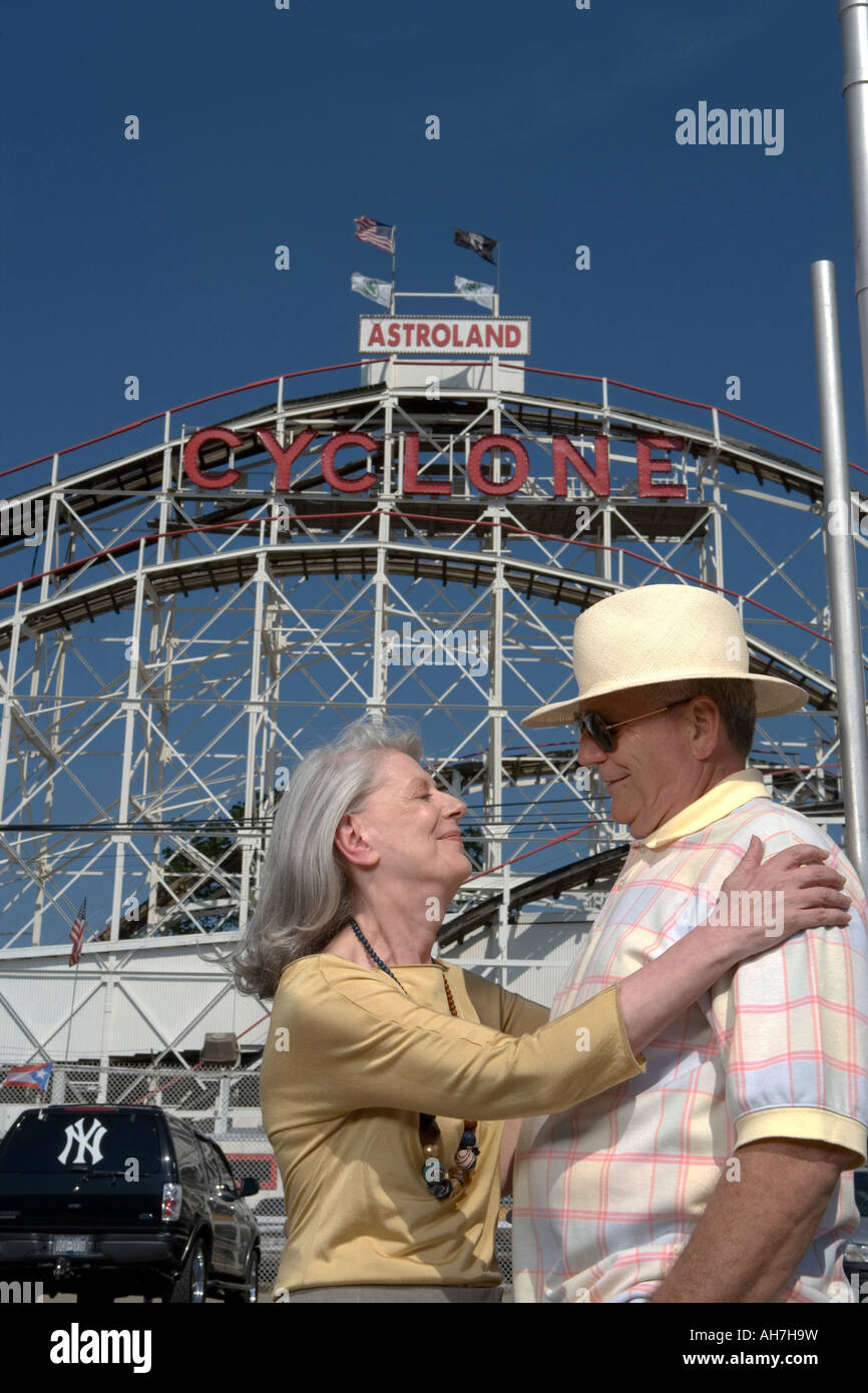 Senior couple in front of a roller coaster, Cyclone Roller Coaster, Coney Island, New York City, New York, USA Stock Photo