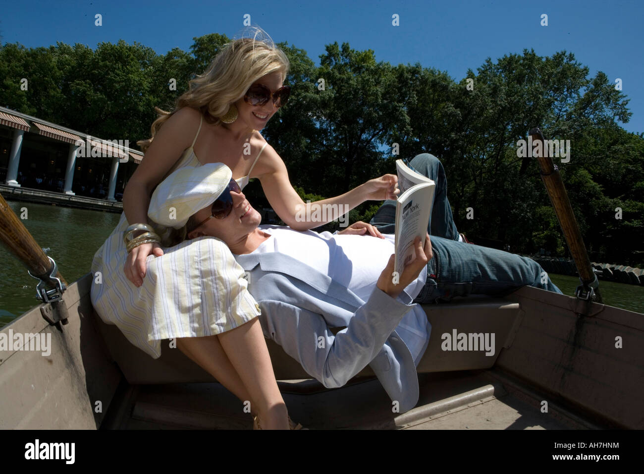 Young woman sitting in a boat with a young man resting on her lap Stock ...