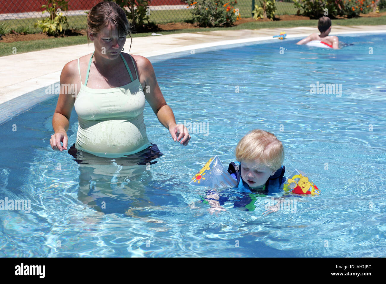 Young boy in buoyancy suit being taught to swim by his pregnant mother Stock Photo Alamy