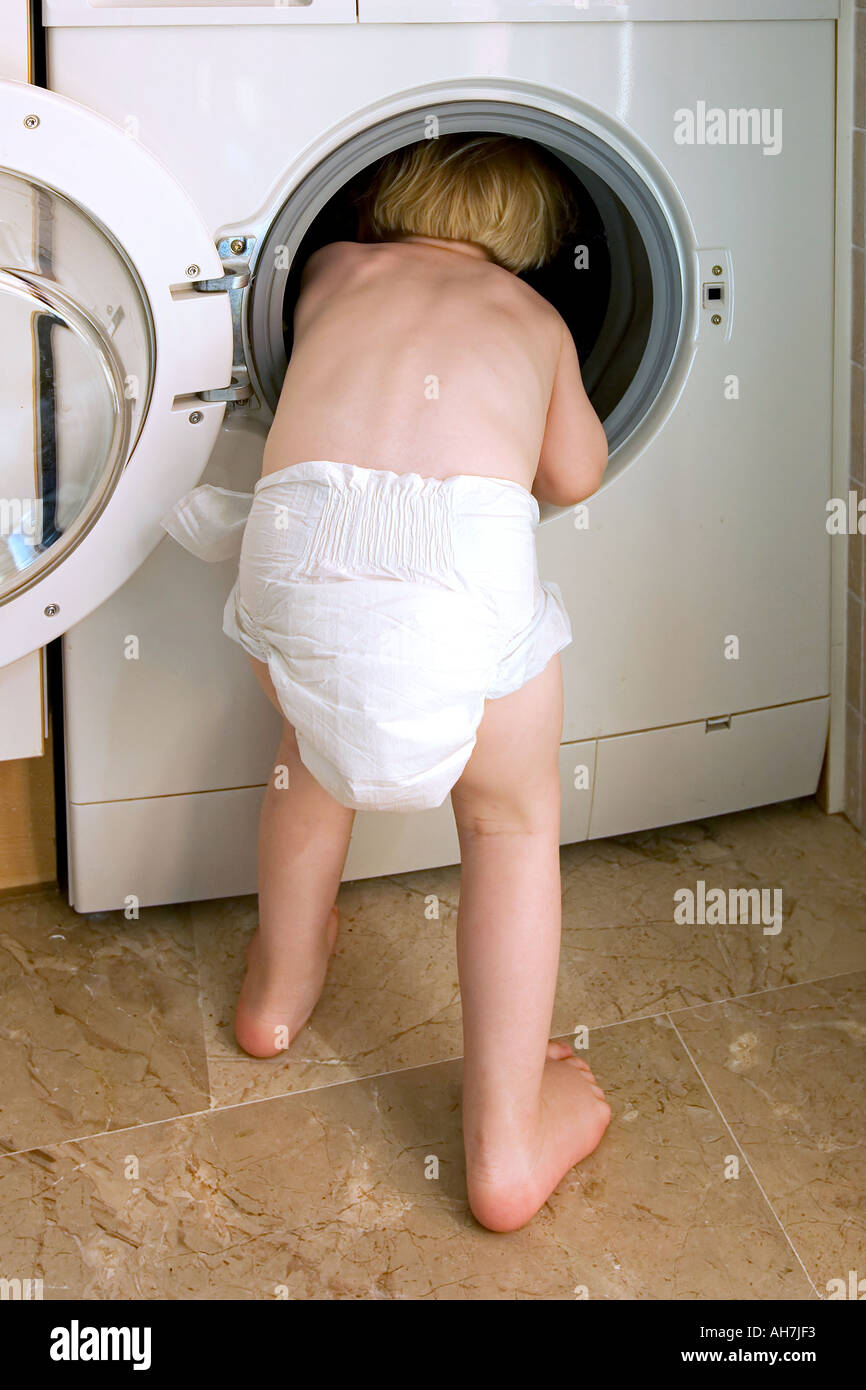 Young child climbing inside a washing machine Stock Photo Alamy