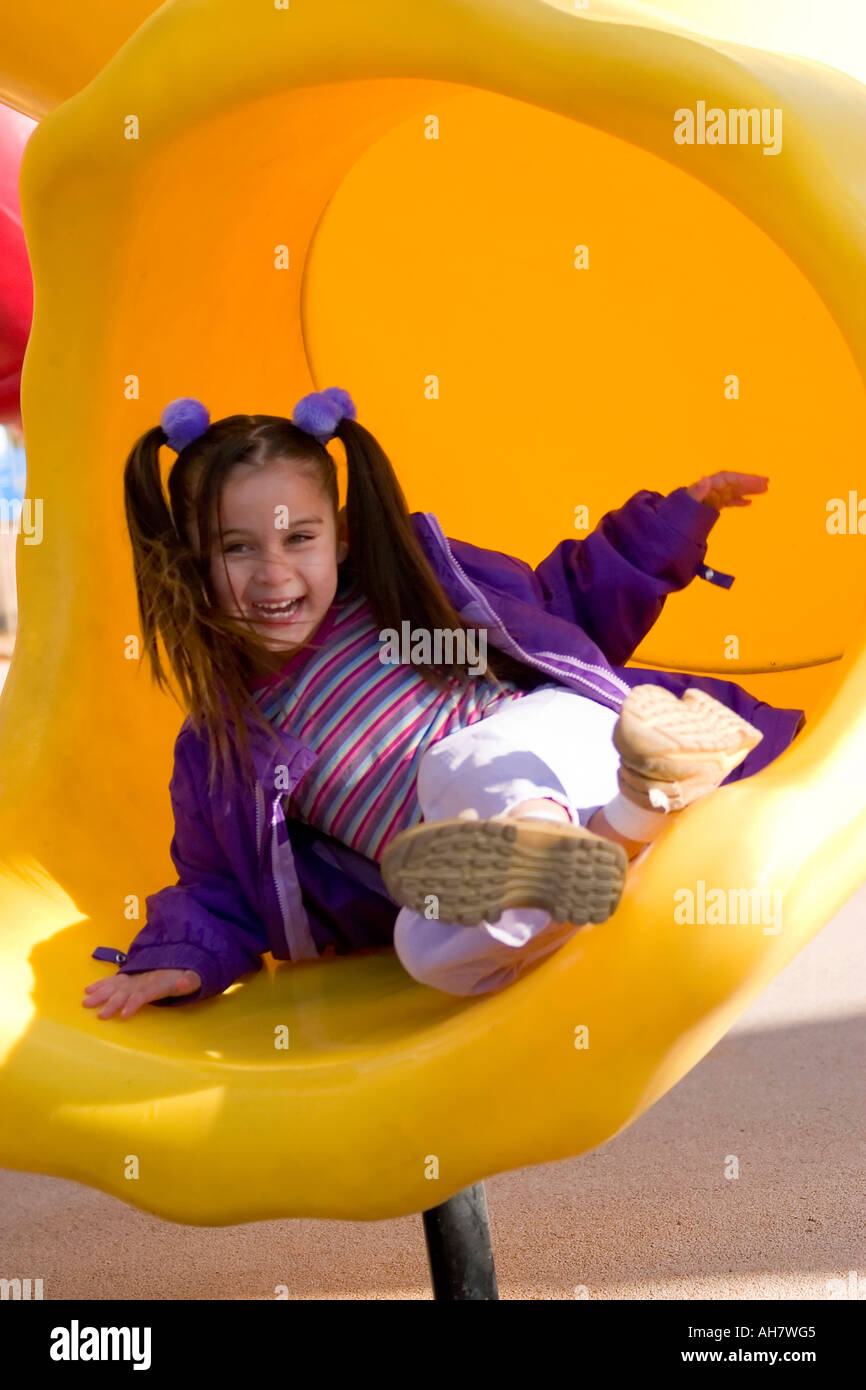 Girl sliding on slide in playground Stock Photo - Alamy