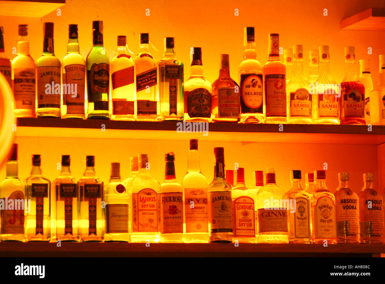 Backlit liquor bottles on shelf behind a bar Stock Photo
