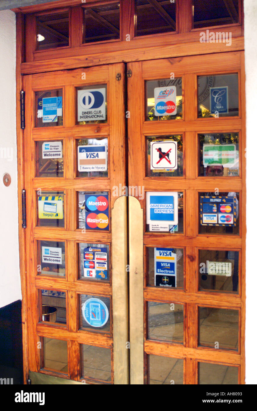 Credit Card Emblems On Glass Of Wooden Restaurant Door Stock Photo