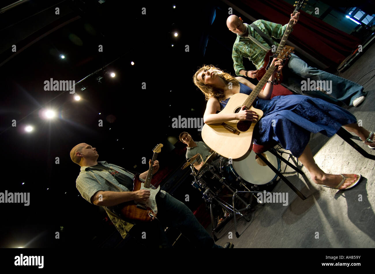 welsh language rock group IGLW rehearsing their act on stage; woman