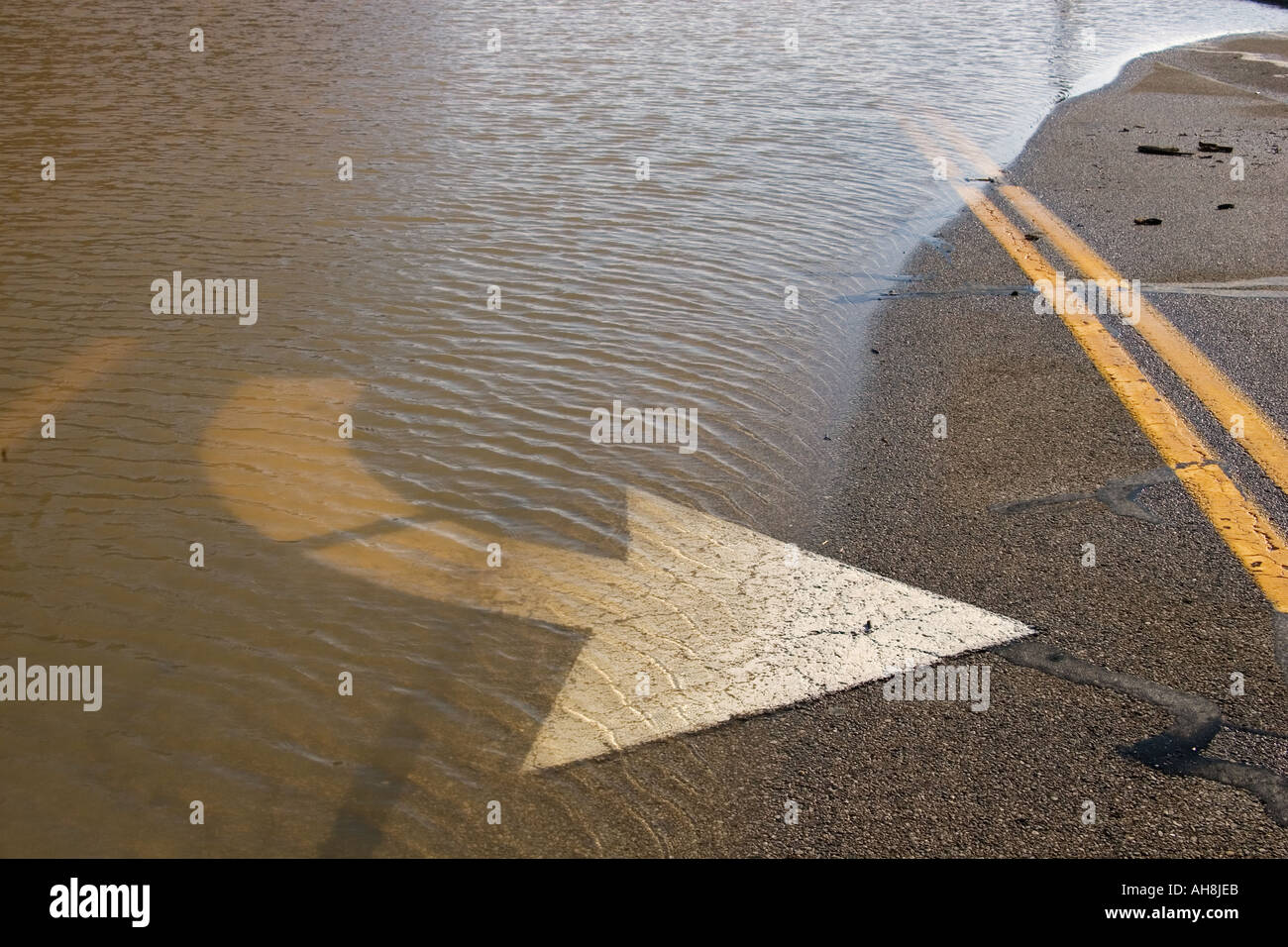 Flood waters rise over roadway in Turning Lane Stock Photo