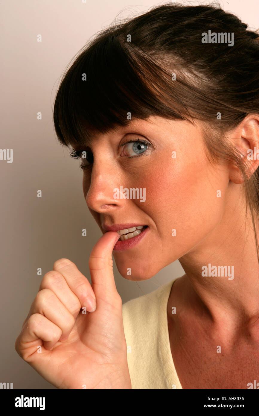 Woman biting her nails expressions anxious nervous stressed worried concerned afraid scared intimidated Stock Photo
